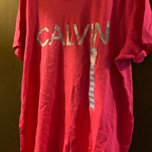 Pink Calvin Klein t-shirt with his name on the bottom side of the t-shirt